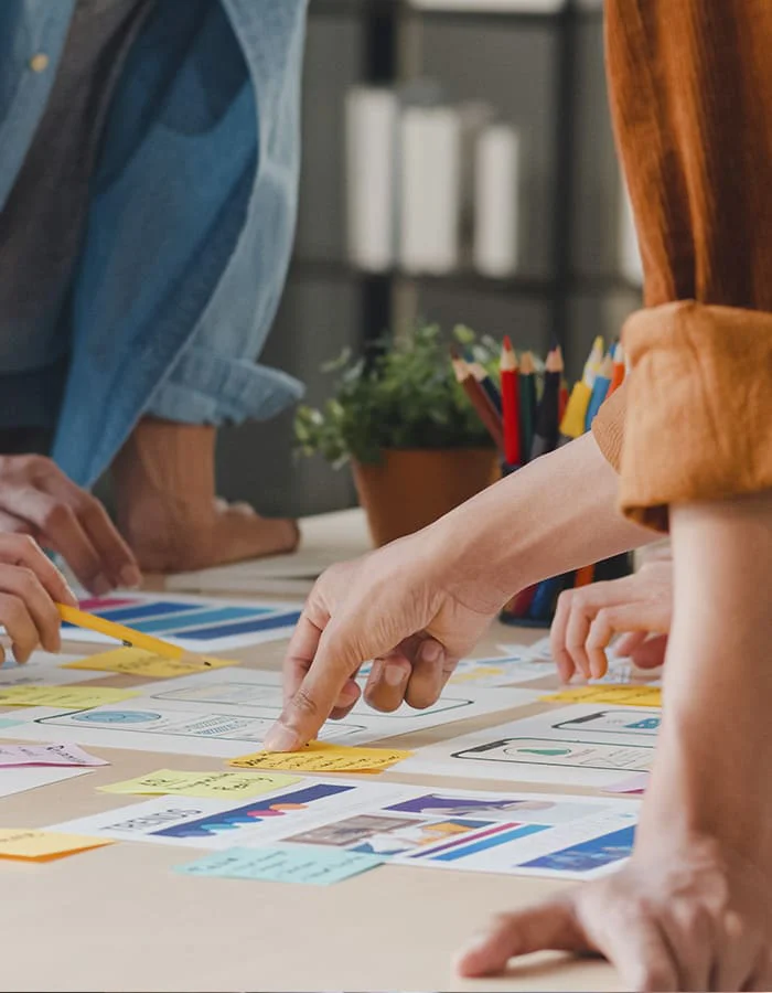 Representación visual de una consultora de diseño y publicidad, con un consultor explicando ideas a un cliente del barrio de Alcobendas, Madrid.